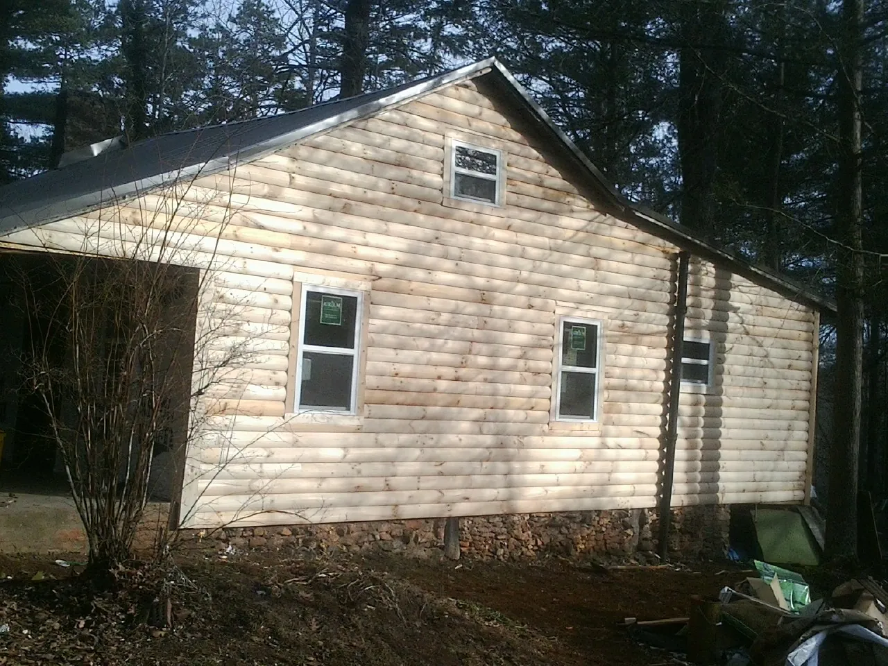 New log siding and dark metal roofing on a gable end in Eidson