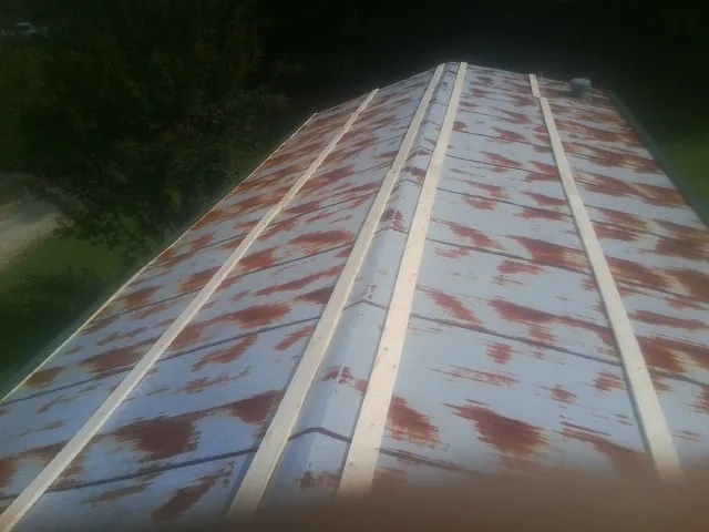 Rusted metal roof panels with new wood purlins before replacement — Storm Damage Roof Repair in Eidson by Roofing Brothers