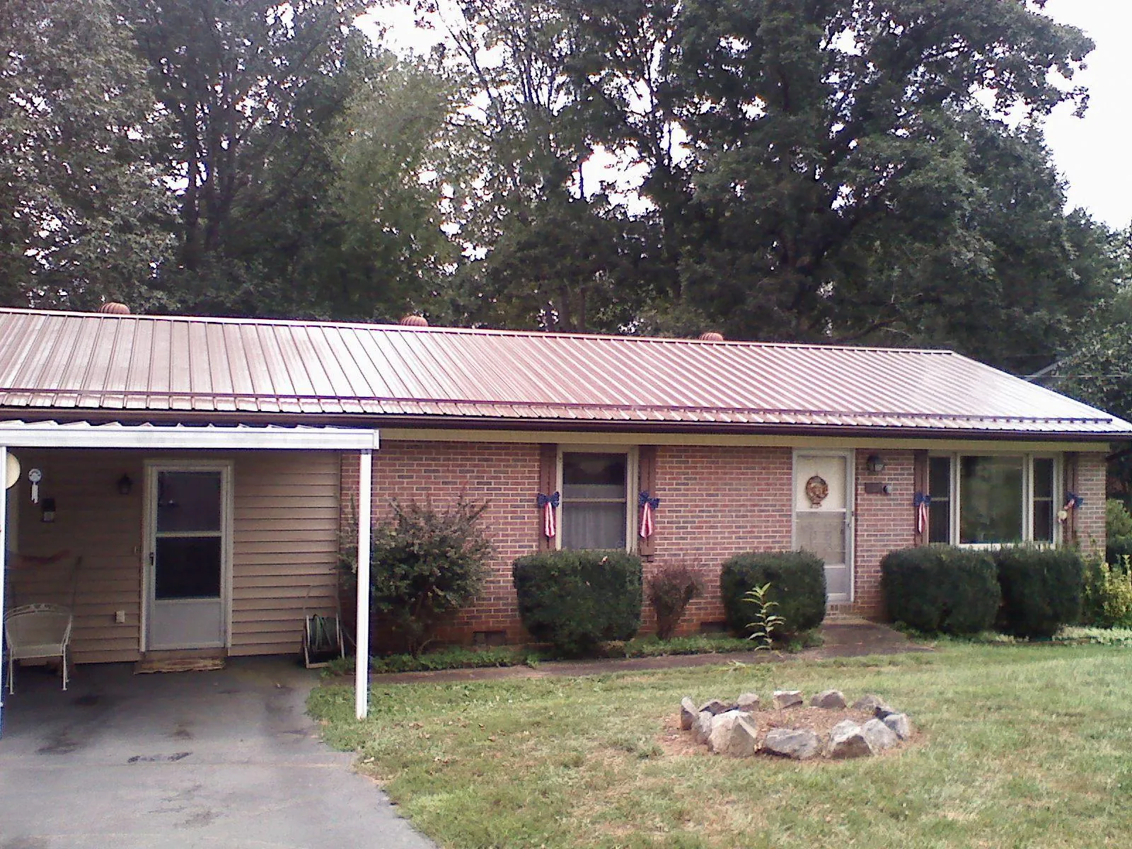 Bronze metal roof and carport on a brick ranch home — Roof Repair work by our crew in Eidson